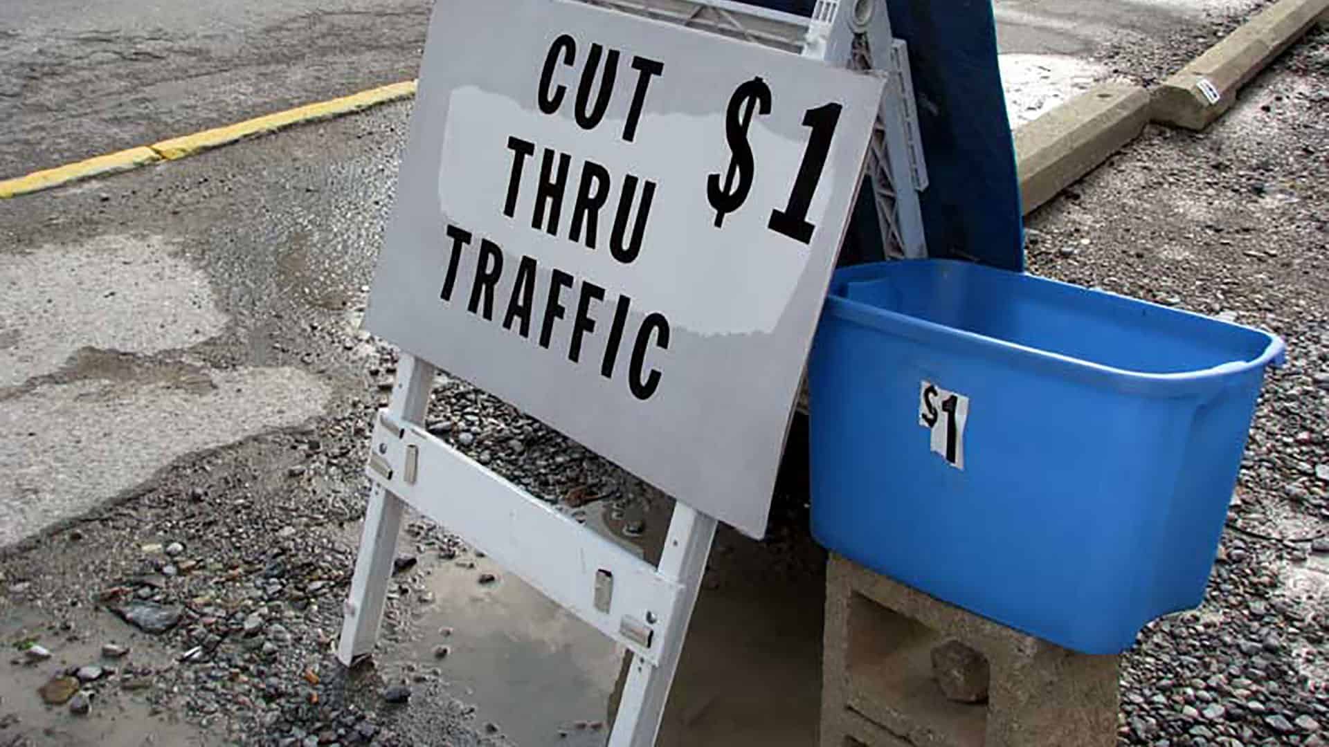 standstill-traffic-header A sign reading: Cut thru traffic $1.